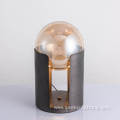 Metal cylindrical base supports glass ball desk lamp